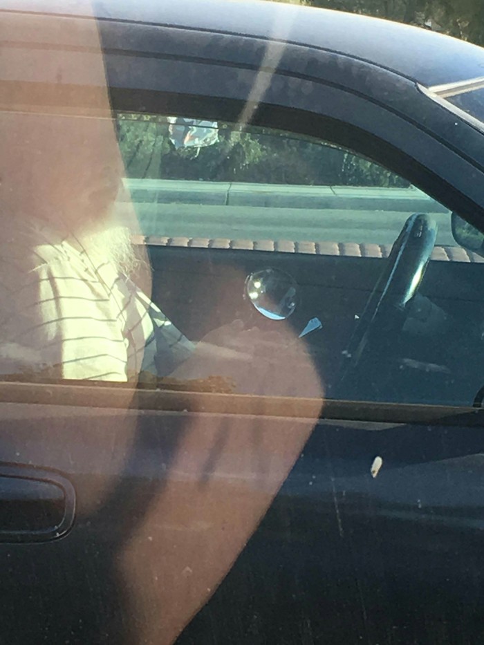 This driver holds a phone with his left hand, a magnifying glass with his right hand to see the phone and headphones in his ears - The driver, Not, Driver, Magnifier, Telephone, Headphones