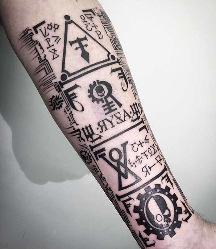 Can anyone tell me the meaning of the symbols (both large and small)? Especially the second one from the bottom - Warhammer 40k, Tattoo